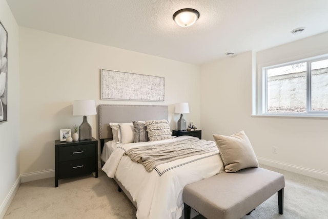 bedroom featuring a textured ceiling and light carpet