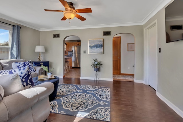 living room featuring ceiling fan, dark hardwood / wood-style flooring, and ornamental molding