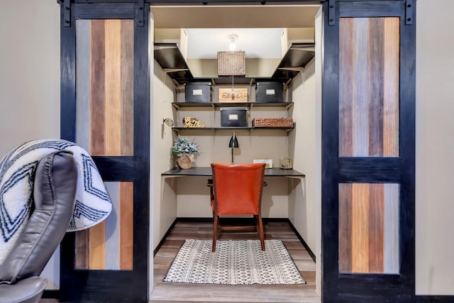 office space with a barn door and dark hardwood / wood-style flooring