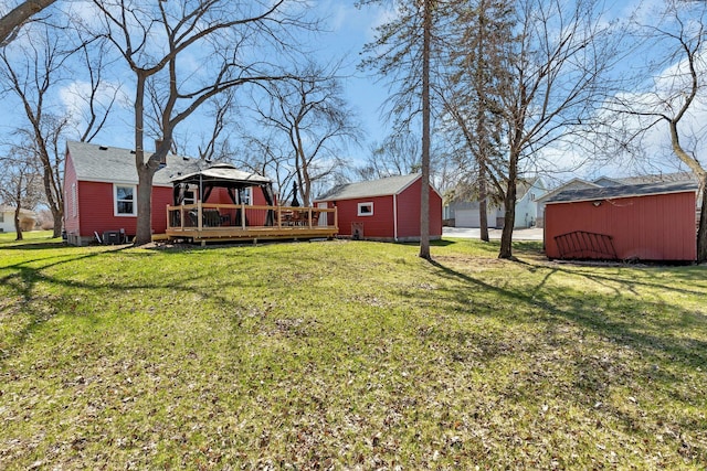 view of yard featuring a gazebo, a storage unit, and a wooden deck