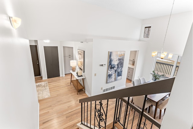 hall with a chandelier and light hardwood / wood-style floors