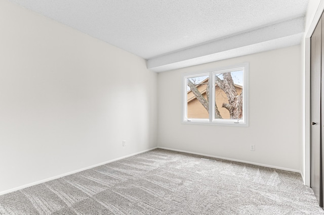 unfurnished room featuring carpet and a textured ceiling