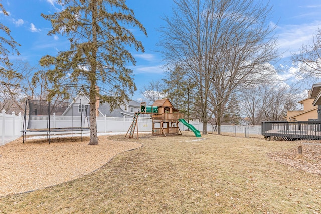 view of yard with a trampoline, a playground, and a deck