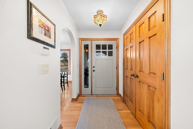 entryway featuring a textured ceiling and light hardwood / wood-style floors