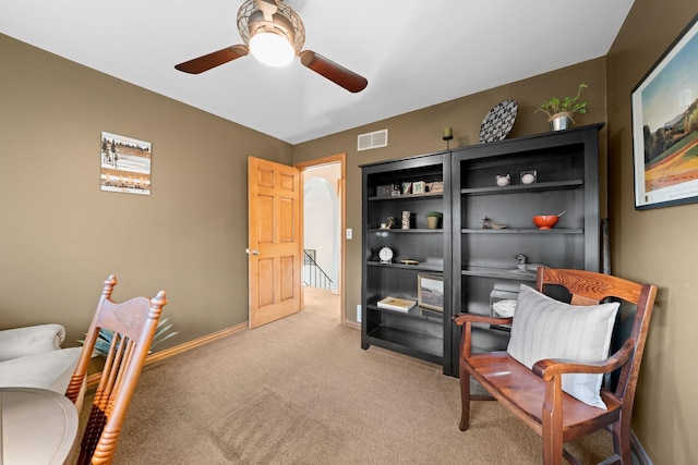 living area with light colored carpet and ceiling fan