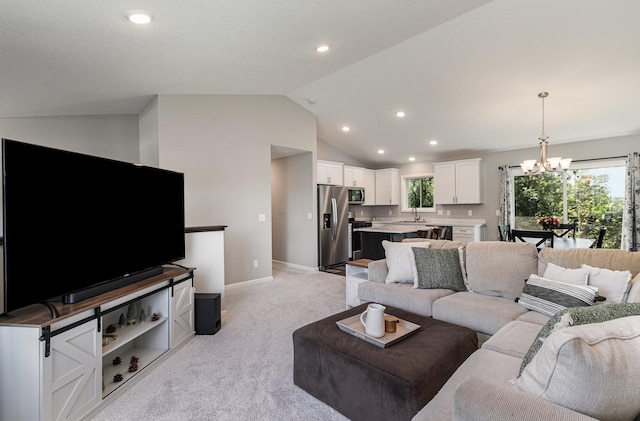 carpeted living room featuring lofted ceiling, sink, plenty of natural light, and a chandelier