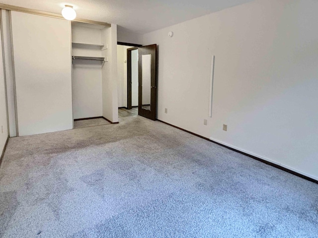 unfurnished bedroom featuring light colored carpet and a closet