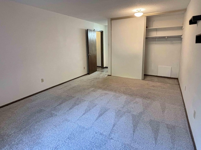 unfurnished bedroom featuring a closet, light colored carpet, and a textured ceiling