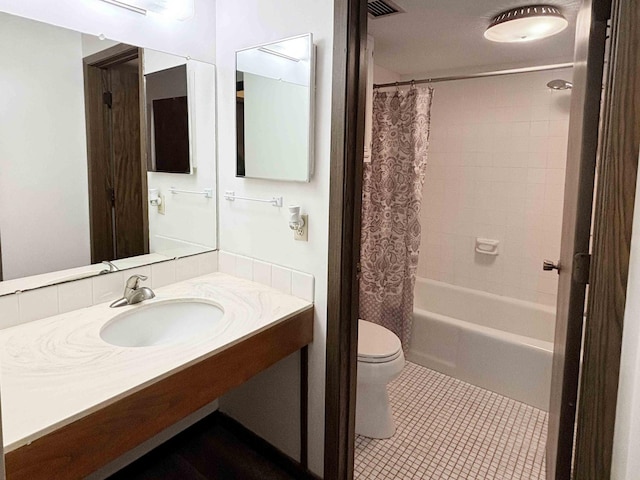 full bathroom with tile patterned floors, toilet, shower / bathtub combination with curtain, and sink