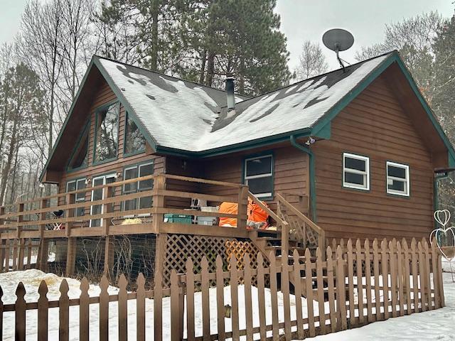 snow covered house featuring a wooden deck