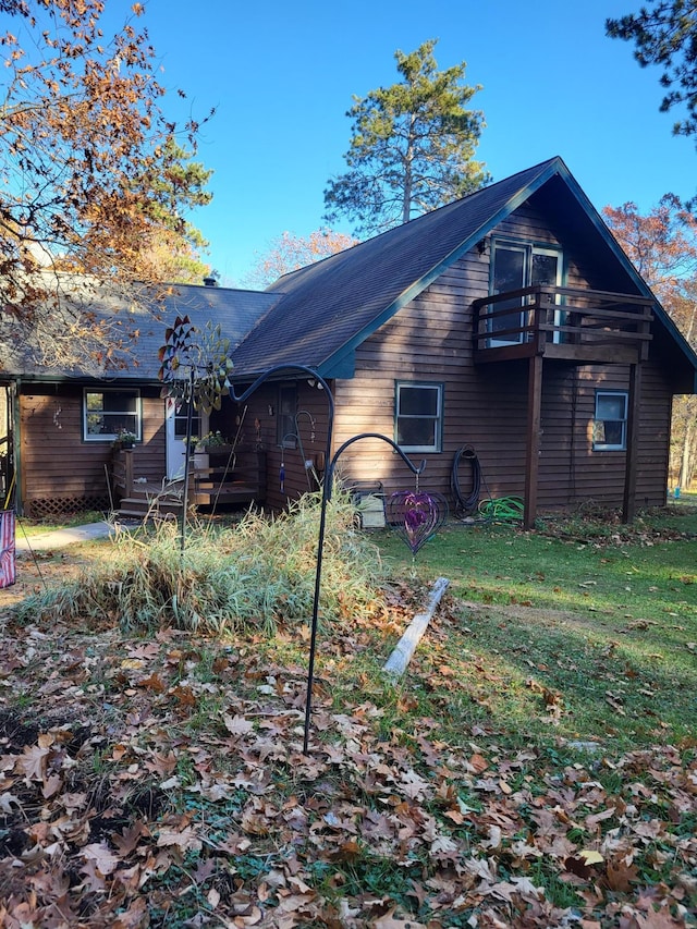 back of property featuring a lawn and a balcony