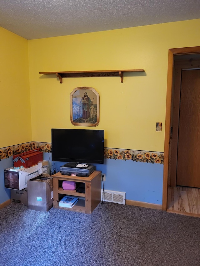 interior space with a textured ceiling and carpet floors