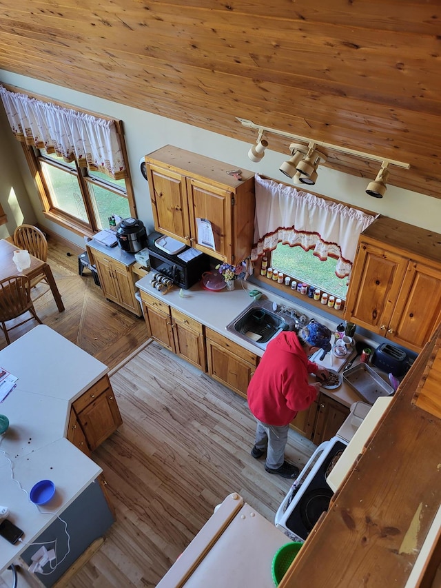 interior space with wooden ceiling, light wood-type flooring, sink, and vaulted ceiling