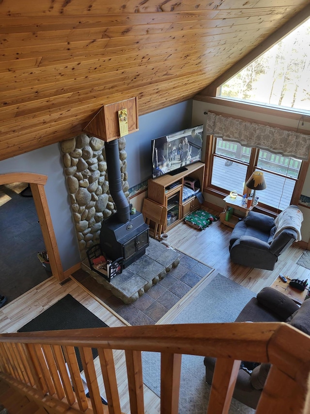 living room featuring hardwood / wood-style flooring, wood ceiling, a wood stove, and vaulted ceiling