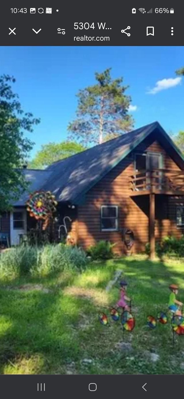 view of home's exterior featuring a yard and a balcony