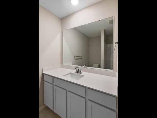 bathroom with tile patterned flooring, vanity, and toilet