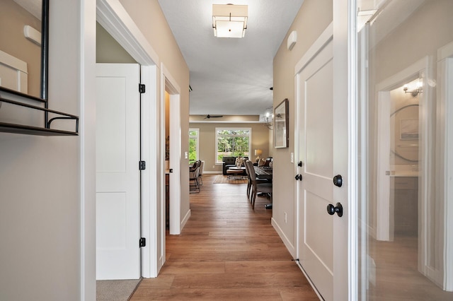 corridor with light hardwood / wood-style floors