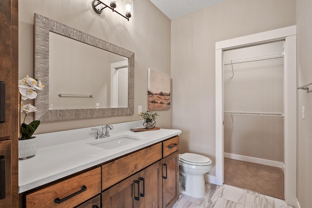 bathroom with a textured ceiling, vanity, and toilet