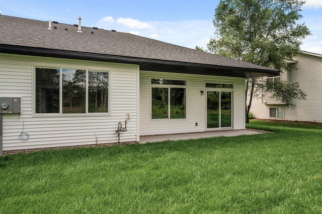 rear view of property featuring a lawn