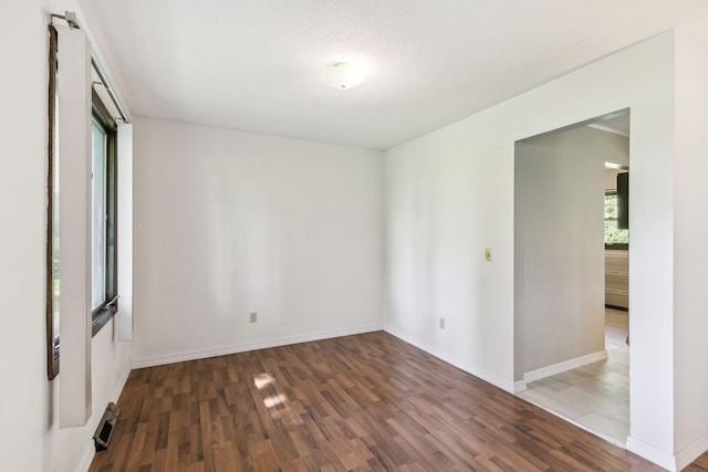 unfurnished room featuring a textured ceiling and dark wood-type flooring