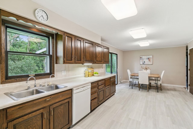 kitchen featuring white dishwasher, sink, a wealth of natural light, and tasteful backsplash