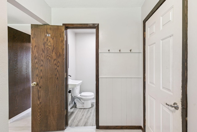 bathroom featuring hardwood / wood-style floors, toilet, and wooden walls