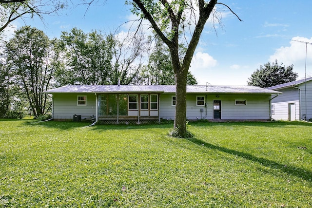 rear view of house featuring central AC and a yard