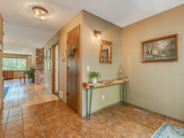 hallway with tile patterned flooring and a textured ceiling