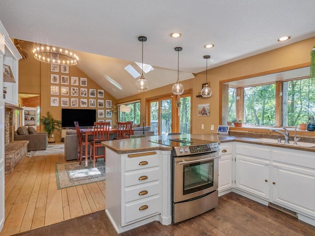 kitchen with hanging light fixtures, electric range, dark hardwood / wood-style flooring, kitchen peninsula, and white cabinets