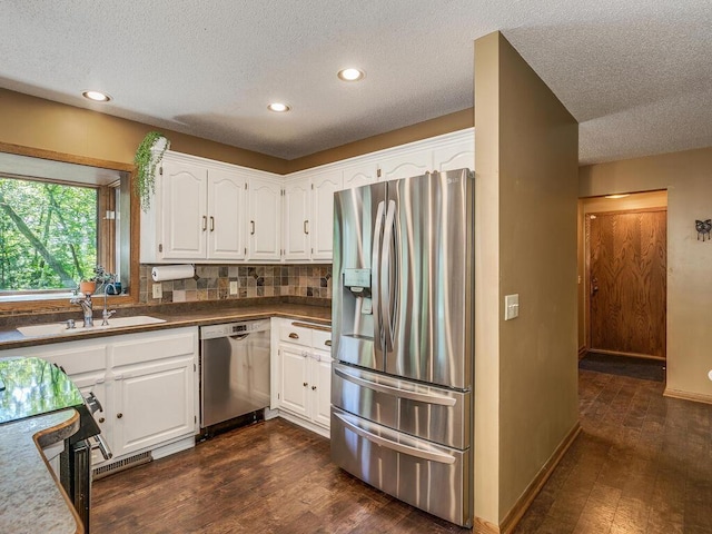 kitchen featuring white cabinetry, backsplash, stainless steel appliances, and a textured ceiling