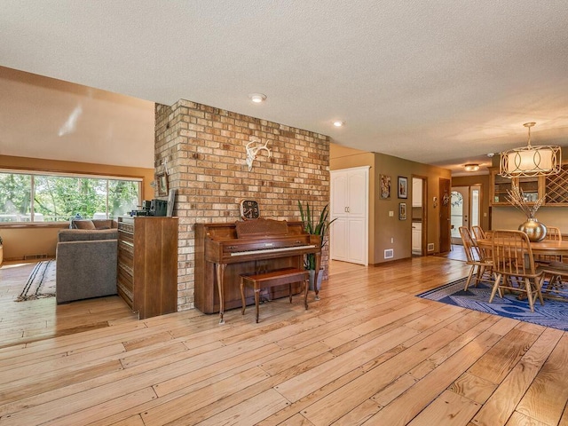 dining room with light hardwood / wood-style flooring and a textured ceiling