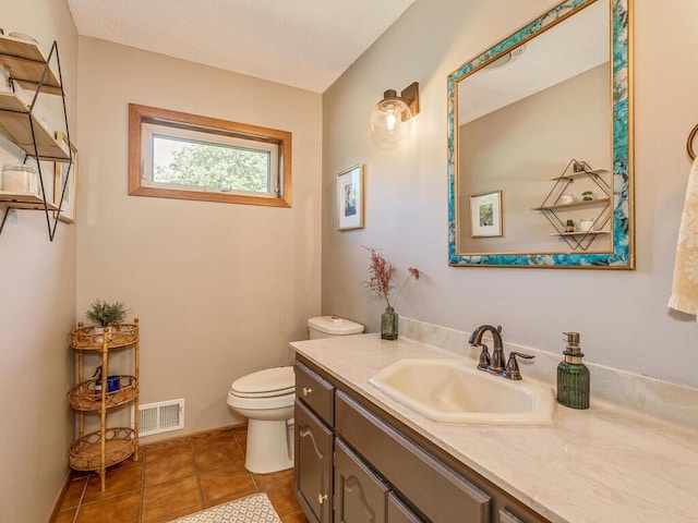 bathroom with vanity, tile patterned flooring, and toilet