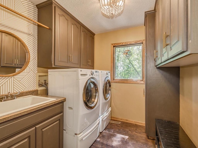 washroom with washer and dryer, sink, a chandelier, cabinets, and a textured ceiling