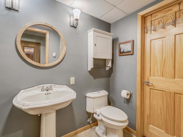 bathroom with toilet, tile patterned flooring, and a drop ceiling