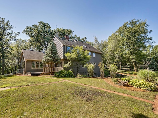 exterior space with a wooden deck and a front lawn