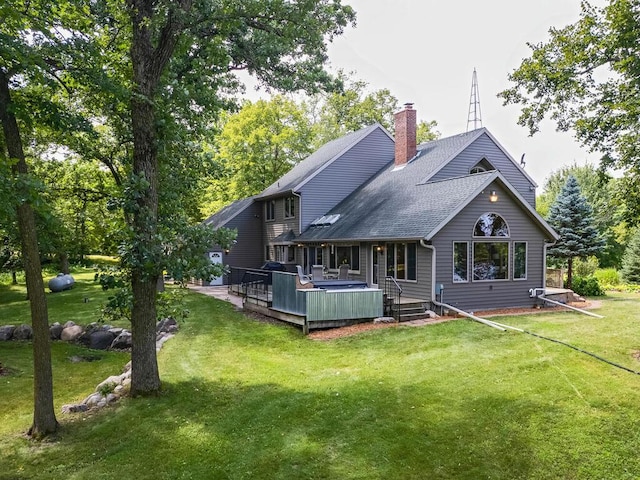 rear view of house featuring a deck and a lawn