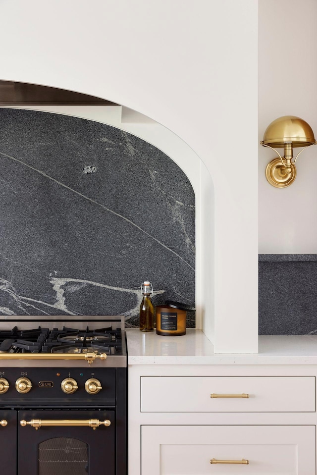 interior space with white cabinetry and high end black range oven