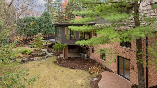 view of home's exterior with a sunroom and central AC unit