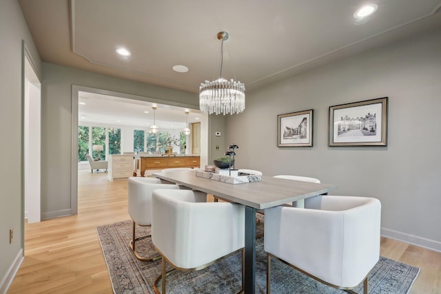 dining area with a chandelier and light hardwood / wood-style floors