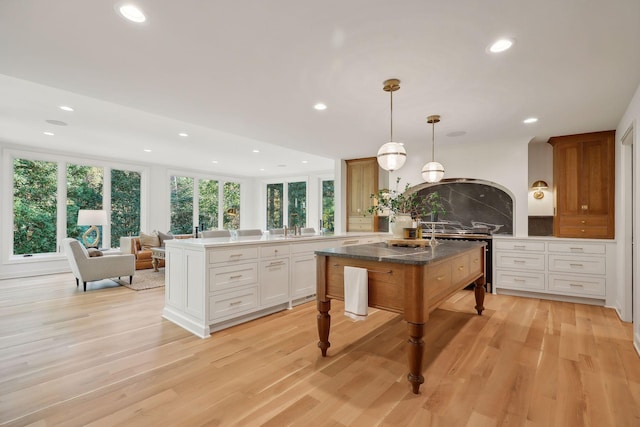 kitchen featuring a center island, hanging light fixtures, kitchen peninsula, and white cabinets