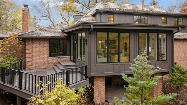 back of house featuring a sunroom and a deck