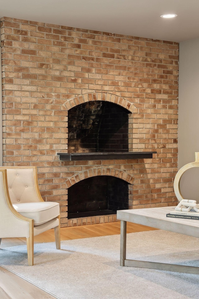 unfurnished room featuring a brick fireplace and hardwood / wood-style floors