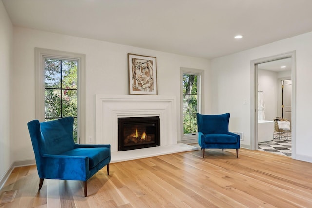 sitting room featuring hardwood / wood-style flooring and a healthy amount of sunlight