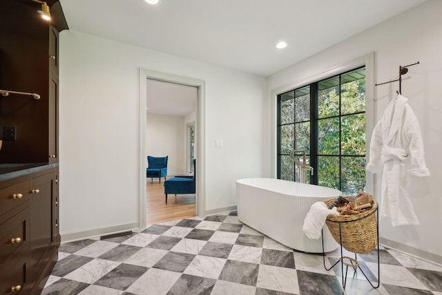 bathroom with vanity, recessed lighting, baseboards, and a freestanding bath