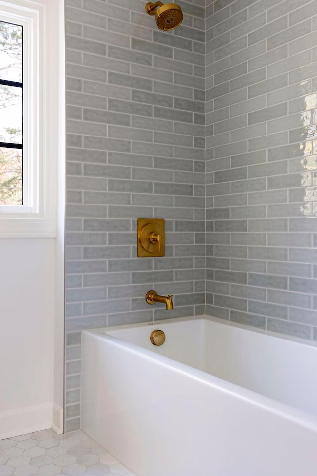 bathroom with tiled shower / bath combo and tile patterned flooring