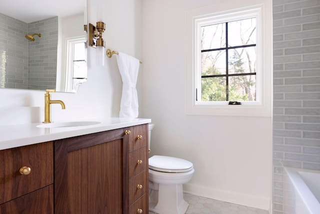 full bathroom featuring vanity, tiled shower / bath, and toilet