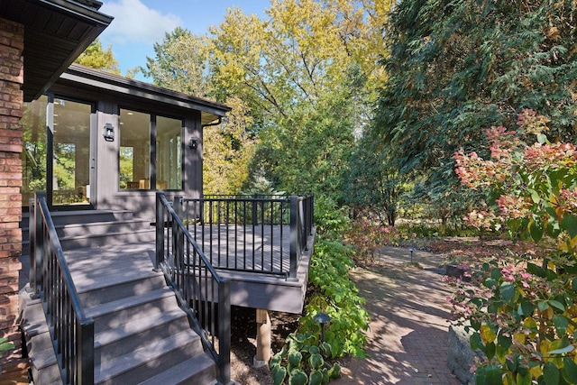 wooden deck featuring stairway and a sunroom