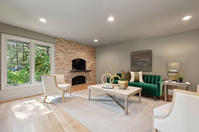 living area featuring recessed lighting, a fireplace, and light wood finished floors