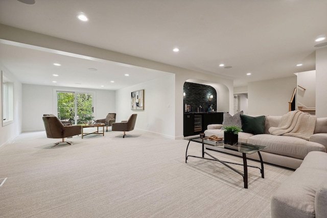 living room featuring recessed lighting, baseboards, light carpet, and stairs