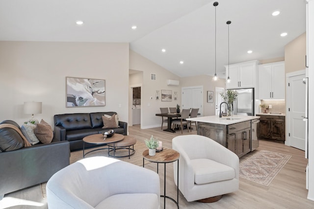 living room with light hardwood / wood-style floors, sink, and vaulted ceiling